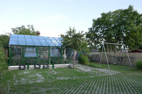 a green house with a playground in a yard at Kisherceg Szálláshely in Budapest