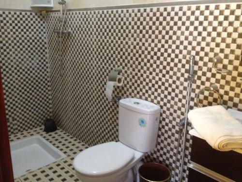 La salle de bains est pourvue de toilettes blanches et d'un lavabo. dans l'établissement Frikrik maison au bord de mer, à Aglou
