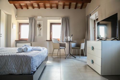a bedroom with a bed and a table with chairs at Cerasus B&B in San Marcello