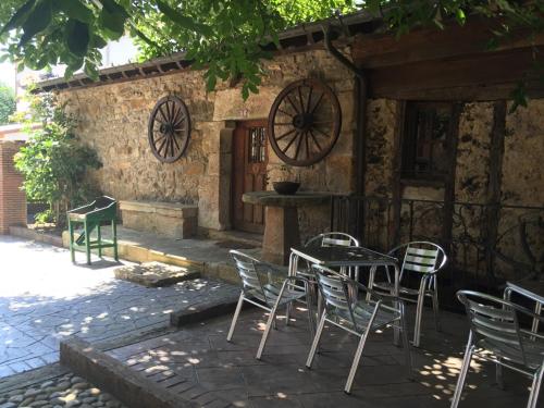 a table and chairs in front of a building at Posada el Molino de Cadalso in Cereceda