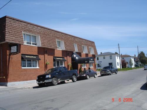 a black truck parked in front of a brick building at Hotel Harbour Grace in Harbour Grace