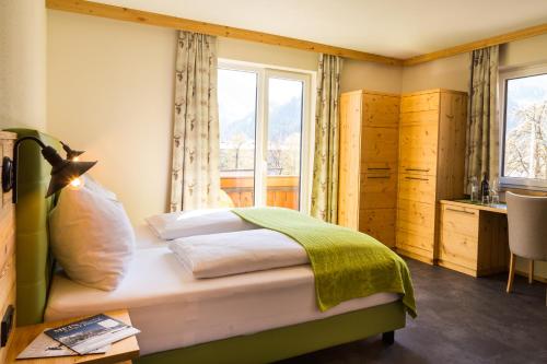 a bedroom with a bed and a window at Hotel Hubertus in Sankt Johann im Pongau