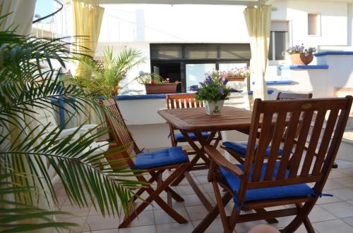 a porch with a wooden table and chairs at Casa Baia smeraldo in Leuca