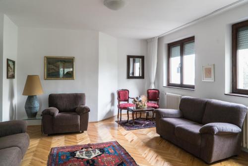a living room with two couches and a table and chairs at Sensitive Apartment in Belgrade