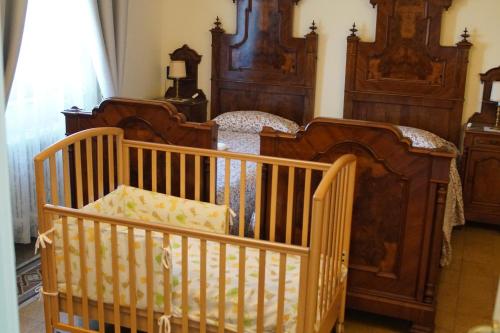 a bedroom with two beds and a crib at B&B La Quiete in Albavilla