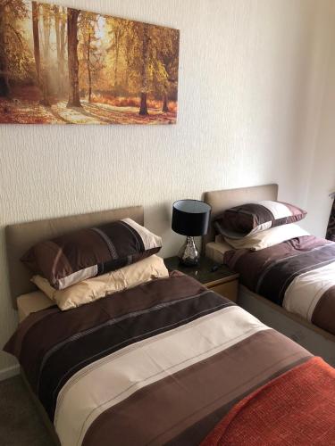 a bedroom with two beds and a painting on the wall at Wellington Tavern Accommodation in Dewsbury