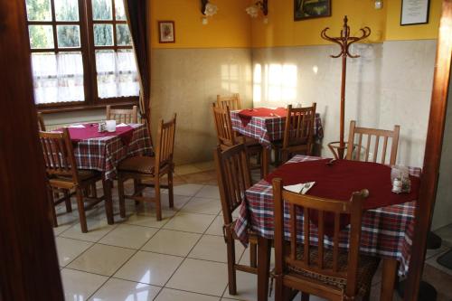 a dining room with tables and chairs with red tablecloths at Kisherceg Szálláshely in Budapest