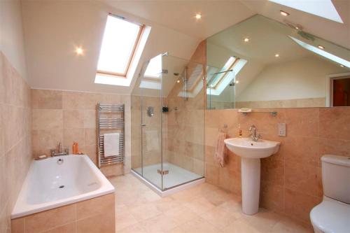 ein Badezimmer mit einer Dusche, einem Waschbecken und einer Badewanne in der Unterkunft Wimbledon Tennis House with Hot Tub; 4 minute walk in London