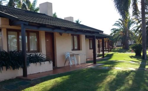 a house with a table and chairs on a porch at Arapey Oasis Termal Hotel in Termas del Arapey