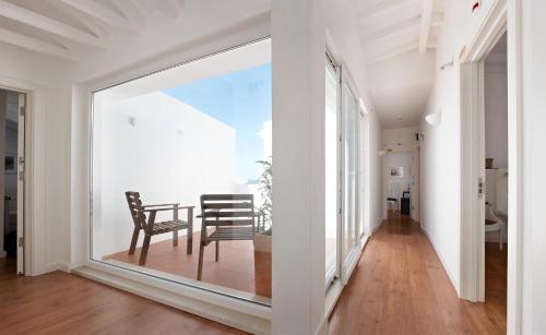 a room with a large window with a table and chair at Casa das Aguarelas in Ericeira