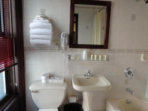 a bathroom with a toilet and a sink and a mirror at Hotel 31 Extended Stay in New York
