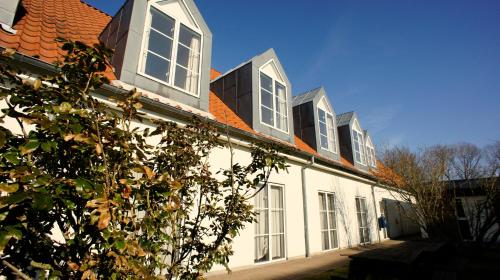 a white building with windows and a roof at Hotel Aarslev Kro in Brabrand