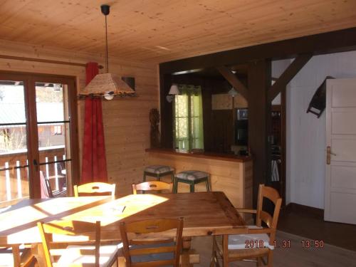 a dining room with a wooden table and chairs at 965 avenue leopold Fabre GITE LE LANTIER in Lans-en-Vercors