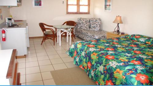 a bedroom with a bed and a table and a kitchen at Aruba Beach Villas in Palm-Eagle Beach