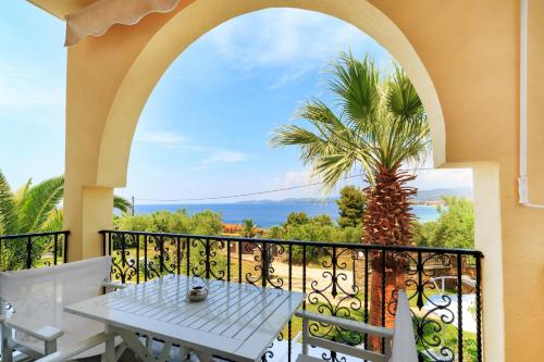 a balcony with a table and a palm tree at Castristudios in Nikiti