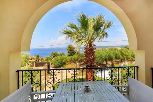 a table on a balcony with a palm tree at Castristudios in Nikiti