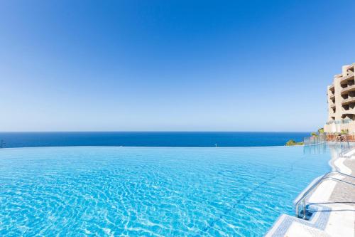 a view of the ocean from a hotel swimming pool at Gloria Palace Royal Hotel & Spa in Puerto Rico de Gran Canaria
