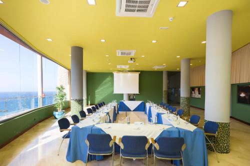 a conference room with tables and chairs and a large window at Gloria Palace Royal Hotel & Spa in Puerto Rico de Gran Canaria
