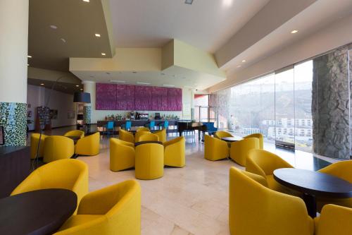 a restaurant with yellow chairs and tables and a cafeteria at Gloria Palace Royal Hotel & Spa in Puerto Rico de Gran Canaria