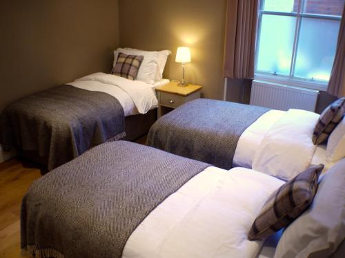 ein Hotelzimmer mit 2 Betten und einem Fenster in der Unterkunft Shieling in Aviemore