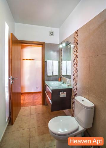 a bathroom with a toilet and a sink and a mirror at Villa Henriques in Funchal