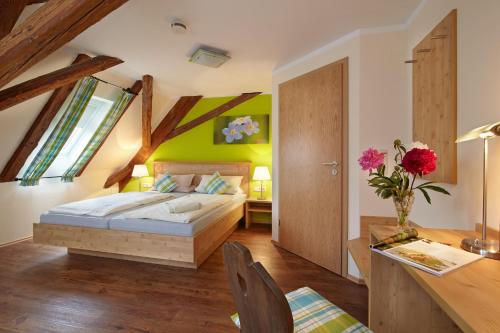 a bedroom with a bed and a desk with a table at Gasthof Goldenes Rössle in Dinkelsbühl