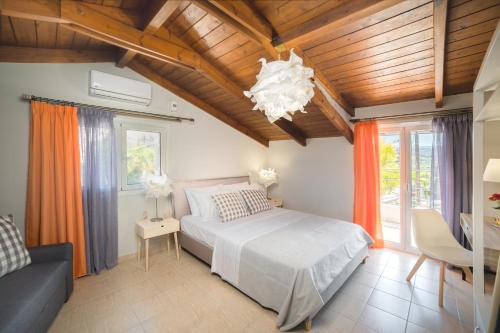 una camera con letto, divano e lampadario a braccio di Villa Provenza a Anafonítria