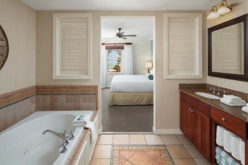een badkamer met een bad en een slaapkamer met een bed bij Hyatt Vacation Club at Windward Pointe in Key West