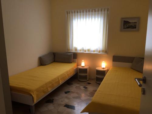 duas camas num pequeno quarto com duas velas em Casa Isabella em Riva San Vitale