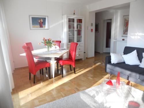 uma sala de estar com uma mesa e cadeiras vermelhas em Ferienwohnung in Bonn em Bonn