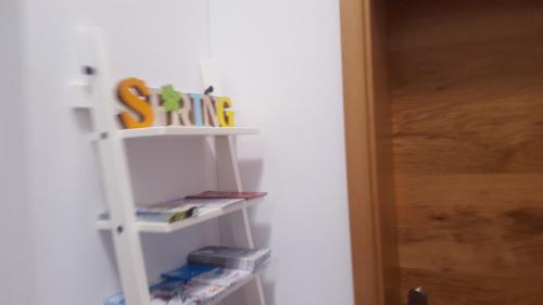 a white shelf with books in a room at Römerstraße 10 KG, Appartement Inntal in Innsbruck