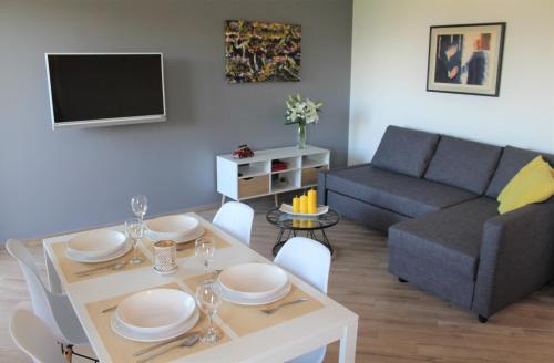 a living room with a table and a couch at Apartmani Marin in Vrbnik