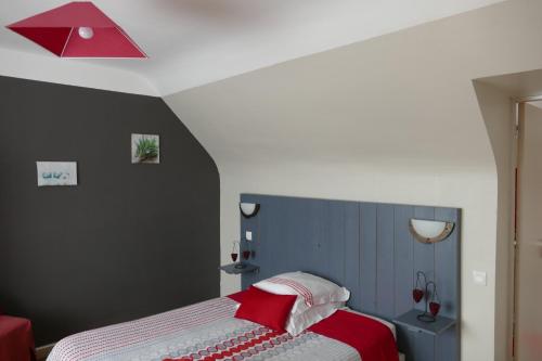 um quarto com uma cama e um tecto vermelho em Chambres d'hotes chez laure & François em Paimpol