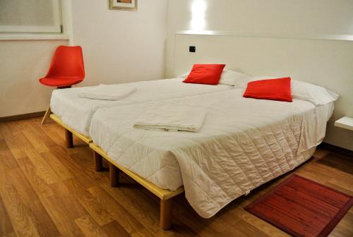 a bedroom with a large bed with red pillows at Agritur Stefenelli in Nago-Torbole