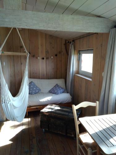 un lit dans une chambre avec un hamac dedans dans l'établissement La cabane en bois, à Villemur-sur-Tarn