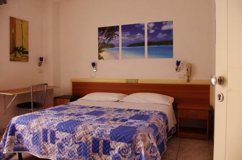 サン・ベネデット・デル・トロントにあるHotel La Playaのベッドルーム1室(ベッド1台付)が備わります。壁には絵画が飾られています。