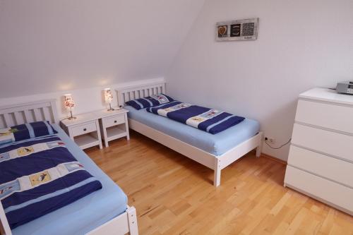 a bedroom with two beds and two night stands at "Strand" - Haus Hartwig in Sankt Peter-Ording