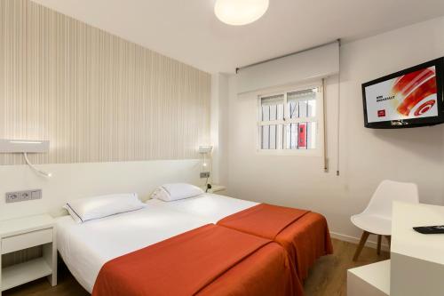 a bedroom with a bed and a flat screen tv at Crown Resorts Club Marbella in La Cala de Mijas