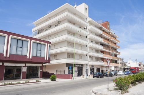 a tall white building on a city street at Attico Saker in Racale