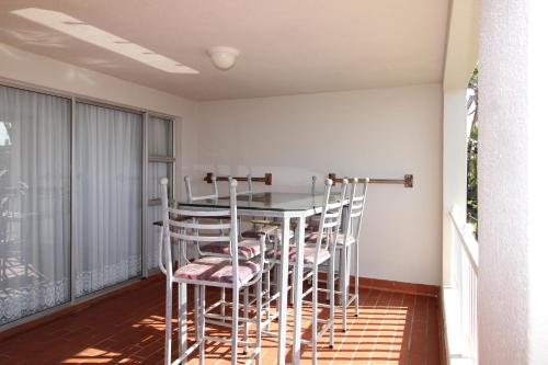 a dining room with a table and chairs on a balcony at Laguna La Crete 94 in Margate