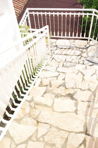 a white fence next to a stone patio at Villa Guci in Ulcinj