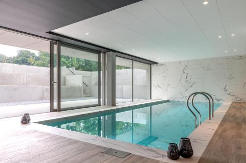 a swimming pool in a house with a stone wall at Martin's Rentmeesterij in Bilzen