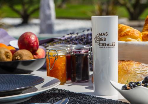 a table with a plate of food and a bottle of preserves at Mas des Cigales in Eygalières