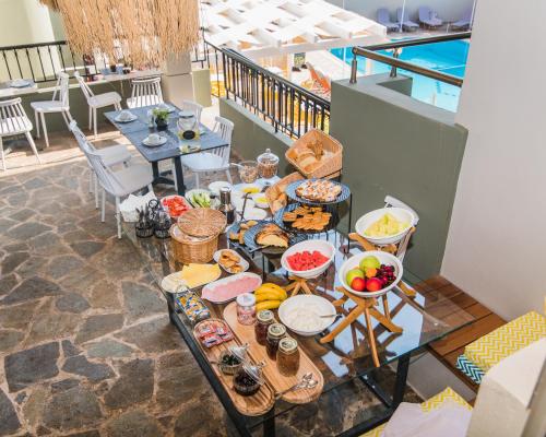 a buffet of food on a table on a balcony at Sunshine Boutique Hotel by Estia in Malia