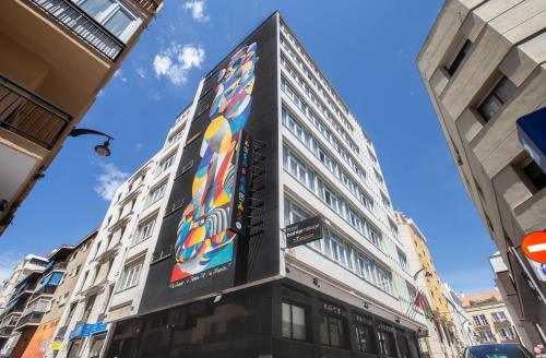 
a tall building with a clock on the side of it at Soho Bahía Málaga in Málaga
