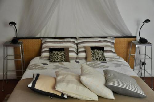 a bed with pillows on it with two lamps at L'Enclos in Lorgues