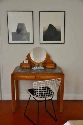 a desk with a mirror and a chair in a room at L'Enclos in Lorgues