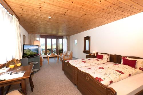 a bedroom with a bed and a television in a room at Hotel Arvenbüel in Amden