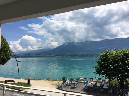 a view of a lake with tables and chairs at Escapade au bord du lac du Bourget in Le Bourget-du-Lac