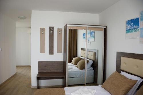 a bedroom with a mirror and a bed in it at studio ASI in Obzor